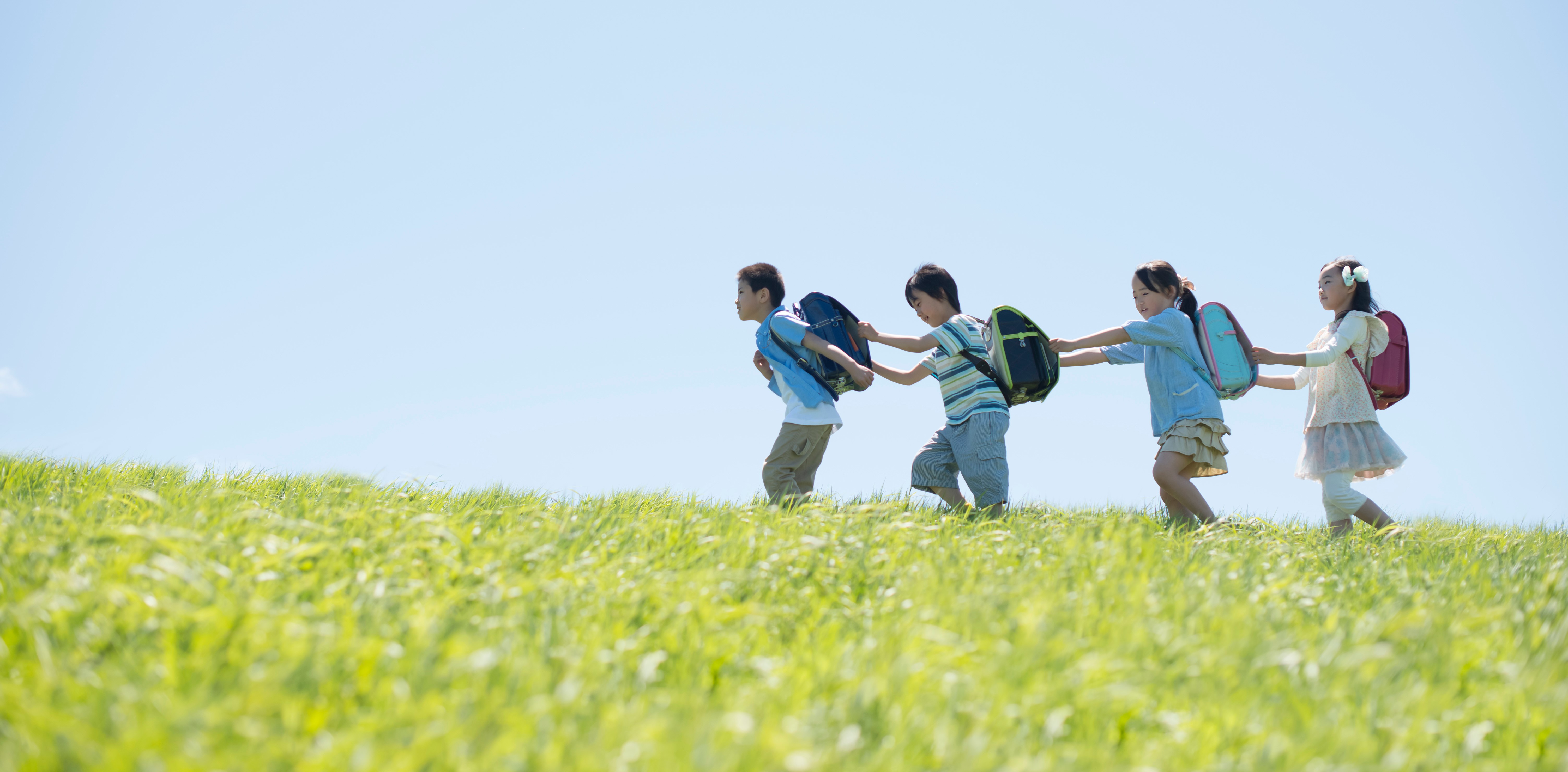 青空の下で歩く子どもたち